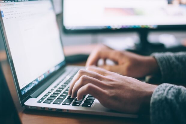 Showing a person typing on a laptop