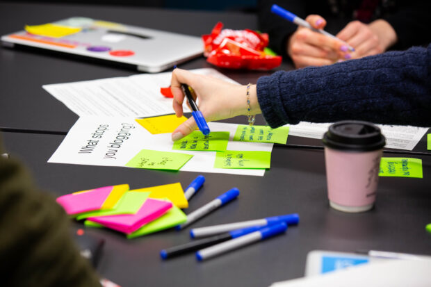 A collection of post-it notes on a table, with a question 'What stops you blogging?' written on a piece of paper behind the notes.